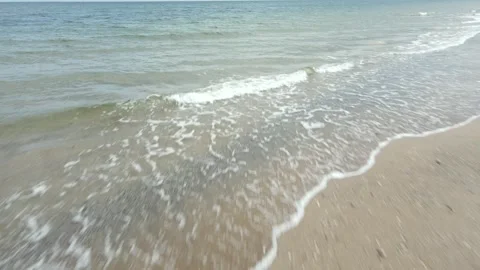 Slow motion of beach with clam shells on waves hitting the sand Stock Footage 245424113