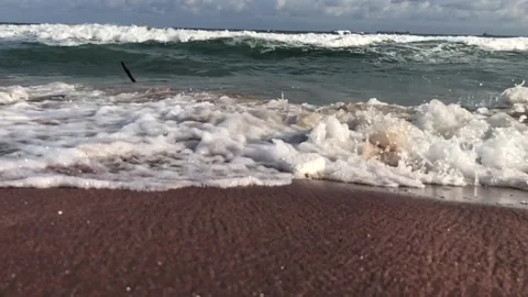 Slow motion of beach tides flowing near Feet Stock Footage 141509847