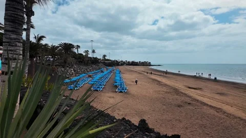 Slow motion beach view with blue sun loungers, Puerto del Carmen, Lanzarote Stock Footage 346376488