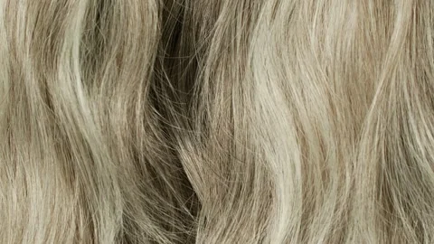 Slow motion of beautiful blond grey long smooth curly hair texture background. Stock Footage 142050484