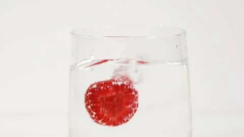 Slow motion of a beautiful raspberry falling into the water Stock Footage 236703074