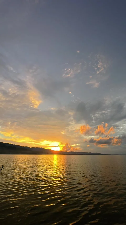 Slow motion of Beautiful sunset on the lake with clouds and mountains Stock Footage 299725482
