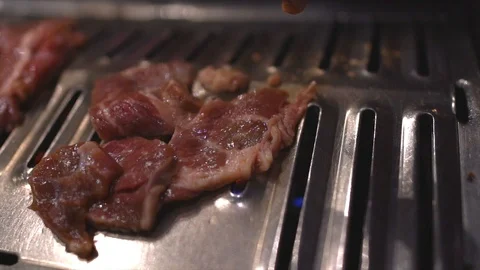 Slow motion beef bulgogi meat placed on hot grill to cook Stock Footage 112732700