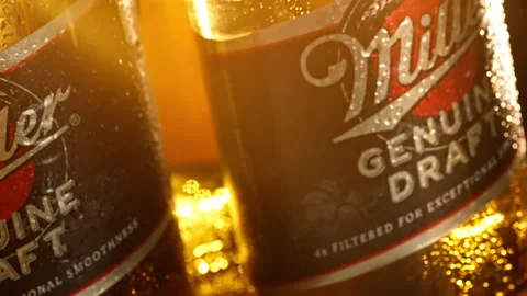 Slow motion as a beer bottle spins on the table in the rain Stock Footage 147945524