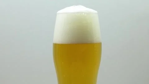 Slow Motion Beer Bubbles Rising in Glass Zooming Out 動画素材 334693650
