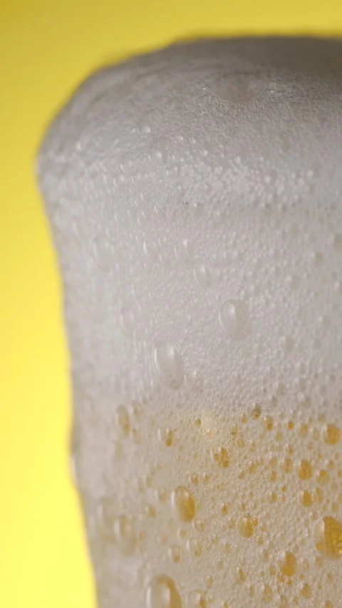 Slow motion beer foam and bubbles in a glass against a bright background Stock Footage 340482646