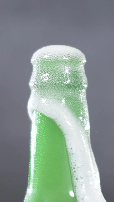 Slow motion beer foam and bubbles from green beer bottle Stock Footage 340482710