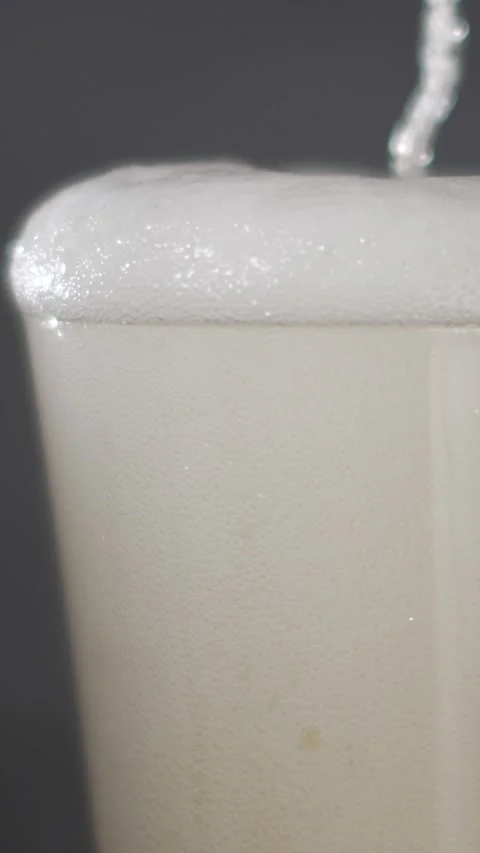 Slow motion beer pouring with foam and bubbles in focus Stock Footage 340482544