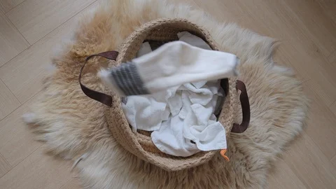Slow Motion of Beige ribbed socks epic filling into a laundry craft basket Video stock 124576207