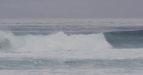 Slow motion of big ocean wave pushing away surfers sitting on their surfboards Stock Footage 156004563