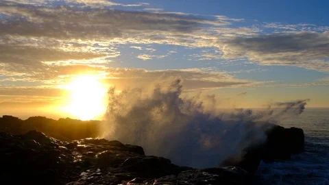 Slow motion of big wave splash backlit by beautiful sunrise over rocky point Vidéo 107779046
