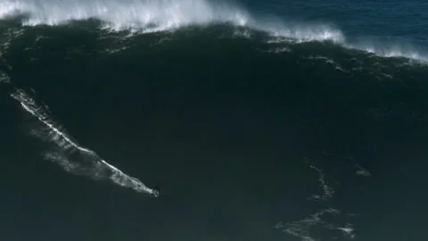 Slow motion of a big wave surfer riding a monster wave in Nazaré, Video stock 142412251