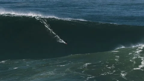 Slow motion of a big wave surfer riding a crazy monster wave in Nazaré, Stock Footage 142413530