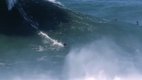Slow motion of a big wave surfer riding one of the biggest waves of the Stock Footage 142413555