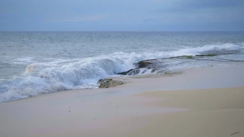 Slow motion of big waves are crushing on rock near sandy beach Stock Footage 114989780