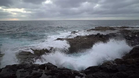 Slow motion big waves breaking on the rocky beach, rock hole where the water Stock Footage 149265283