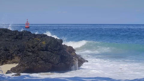 Slow motion of big waves with splashes on black rocky beach Video stock 114689414