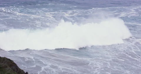 Slow motion of bigger ocean wave swimming towards rocky shore of cliff Stock Footage 156109235