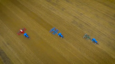 Slow motion birds-eye view aerial drone footage of tractors ploughing Stock Footage 59864594