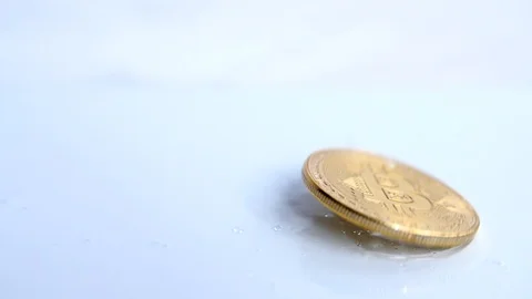 Slow motion -Bitcoin gold crypto currency being dropped onto soap bubble  Stock Footage 85760087