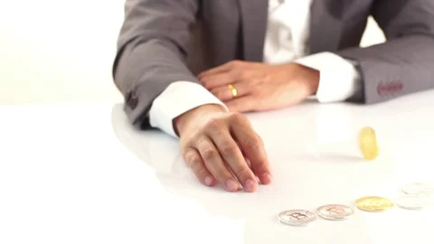 Slow motion Bitcoin spin on a table with business man hand. Stock Footage 87773156