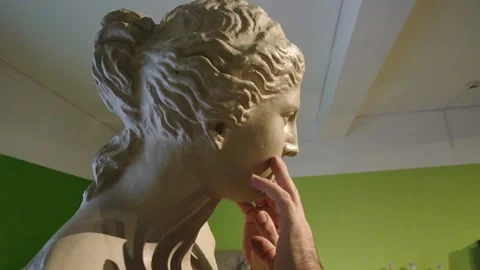 Slow motion of blind man's hands touching the face of a copy of Venus de Mil Stock Footage 140987555