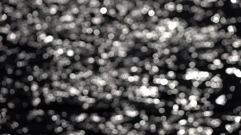 Slow motion of blinking mica like specks on ripple water with low sun reflection Stock Footage 119883210