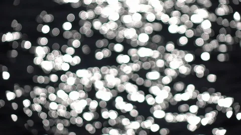 Slow motion of blinking specks on blurred ripple water with low sun reflection. Stock Footage 120989416