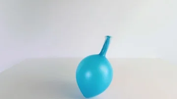 Slow motion of a blue balloon deflating on a white background Stock Footage