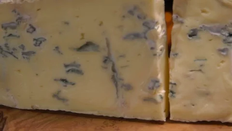 Slow-motion of blue cheese falling on the wooden board Stock Footage