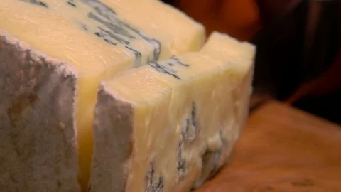 Slow-motion of blue cheese falling on the wooden board Stock Footage