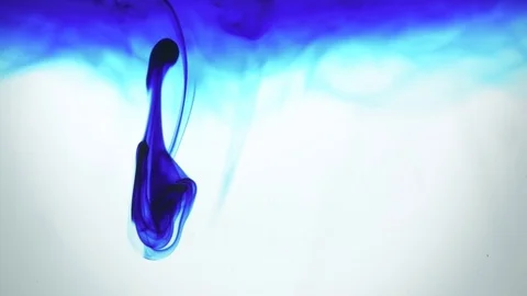 Slow motion, blue dye and ink being dropped on water, macro closeup Stock Footage 79364889