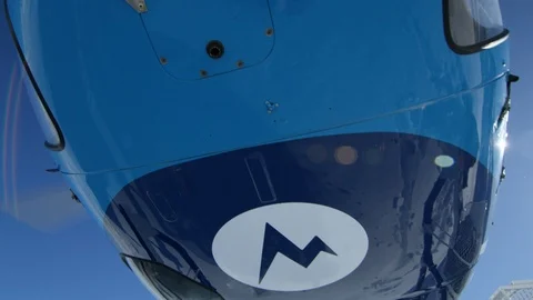 Slow motion of blue helicopter with skiing gear on side taking off in air Stock Footage 129128146