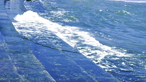 Slow motion blue waves comes to granite stairs on city riverside Stock-Footage 99136751