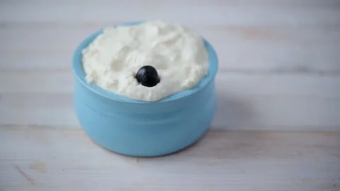 Slow motion of blueberries dropping into quark dessert Stock Footage 113574489