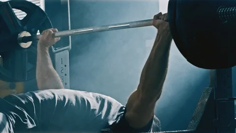 Slow motion of a bodybuilder lifting heavy barbell weights Stock Footage 88091309