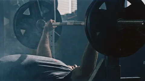 Slow motion of a bodybuilder lifting heavy barbell weights Video stock 88091549