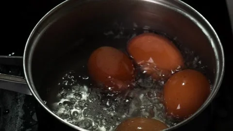 Slow Motion Boiling Brown Eggs in Pot with Bubbling Water Close Up Видео 330183890