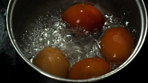 Slow Motion Boiling Brown Eggs in Pot with Bubbling Water Close Up Видео 330183897