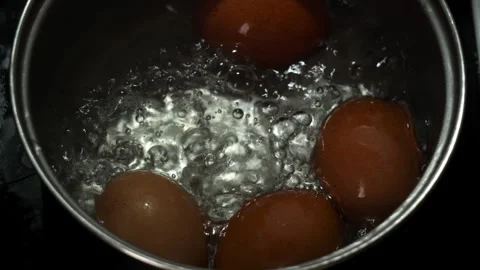 Slow Motion Boiling Brown Eggs in Pot with Bubbling Water Close Up Видео 330183909