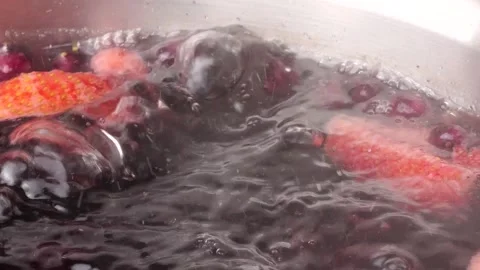 Slow motion boiling fruit compote in stainless steel pot Stock Footage 305521087