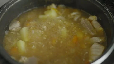 Slow motion of boiling soup with meat, potatoes and vegetables Stock Footage 335391108