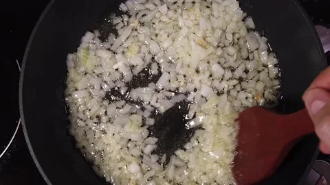 Slow motion bolognese cooking process. Onions are fried in a pan. The cook st Stock Footage 221853893