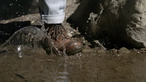 Slow Motion as Boost Steps Into a Puddle of Water and Splashes Stock Footage 270318829