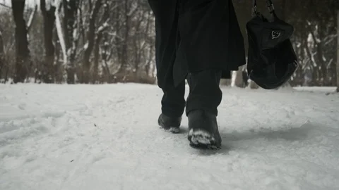 Slow motion Bottom angle: Man in black cloak walking through park. 60fps. Stock Footage 102192192
