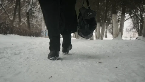 Slow motion Bottom angle: Man in black cloak walking through park. 60fps. Stockbeeldmateriaal 102192394