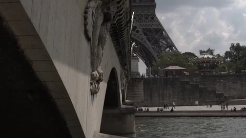 SLOW MOTION: Bottom of Eiffel Tower of Paris appears behind bridge on Boat Stock Footage 105554699