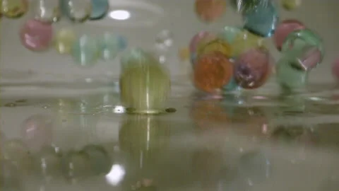 Slow motion bouncing water beads colourful background Stock Footage 144704233