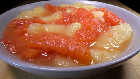Slow motion – Bowl of mixed normal and ruby red grapefruit slices. Stock Footage 108037703