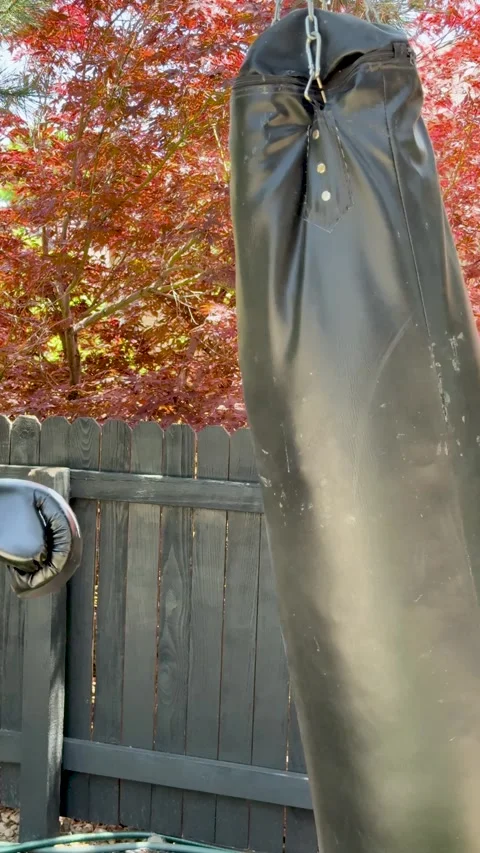Slow-motion of boxing gloves hitting a punching bag outdoors 库存影片 312105278